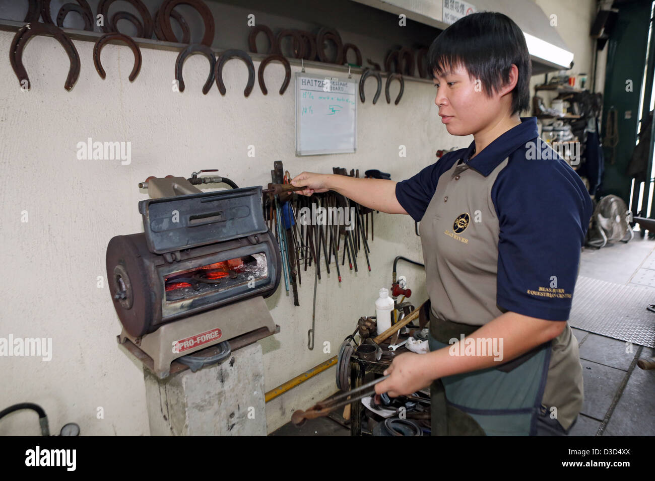 Sheung Shui, la Chine, l'Hufschmiedin horseshoe chauffées dans un four Banque D'Images