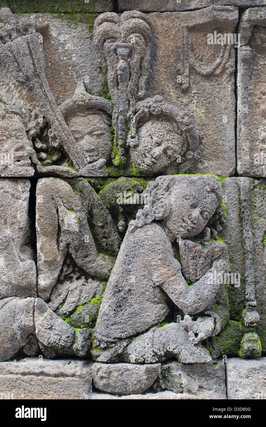 Figurines bouddhistes sculptées ornent les murs de la Buddhist Temple à Borobudur à Java, Indonésie Banque D'Images