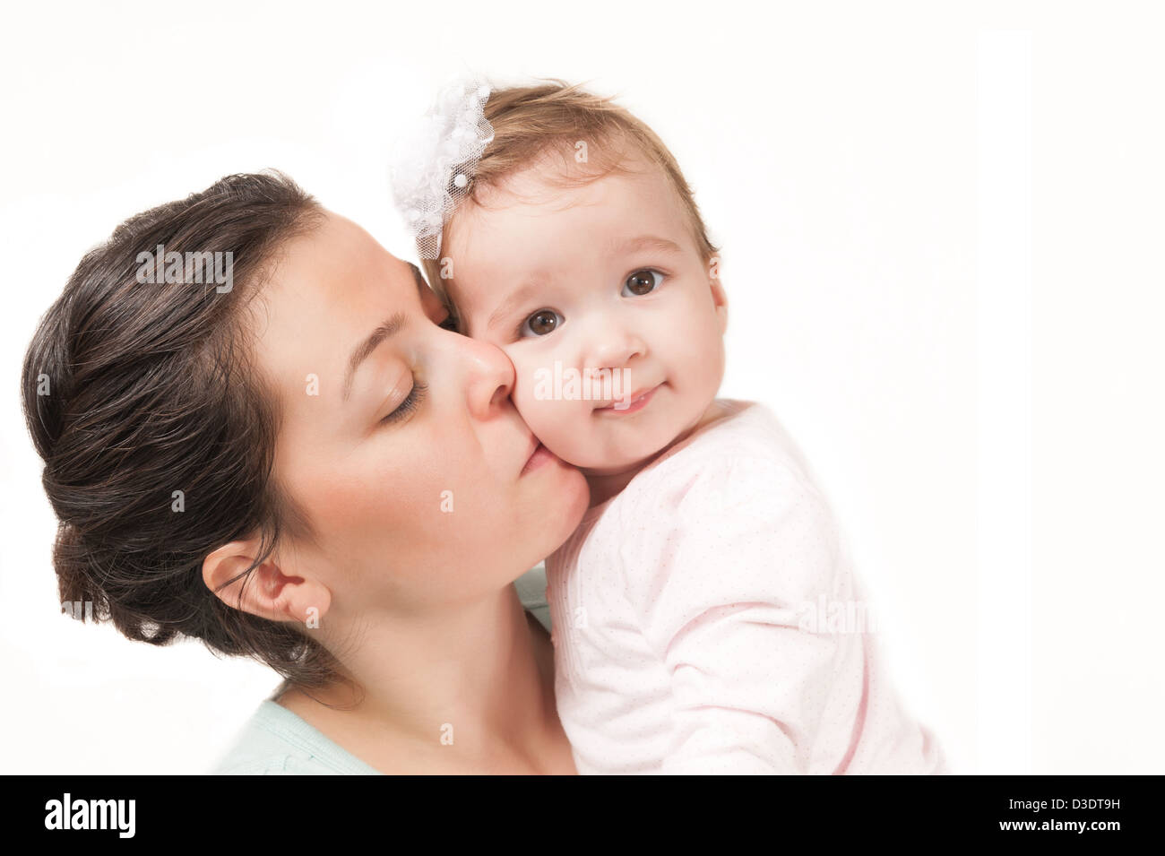 Mère embrassant son bébé fille isolée sur fond blanc Banque D'Images