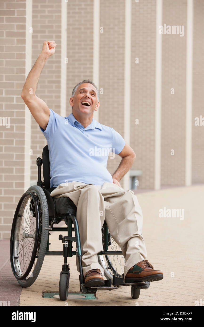 L'homme en fauteuil roulant avec de la moelle épinière cheering Banque D'Images