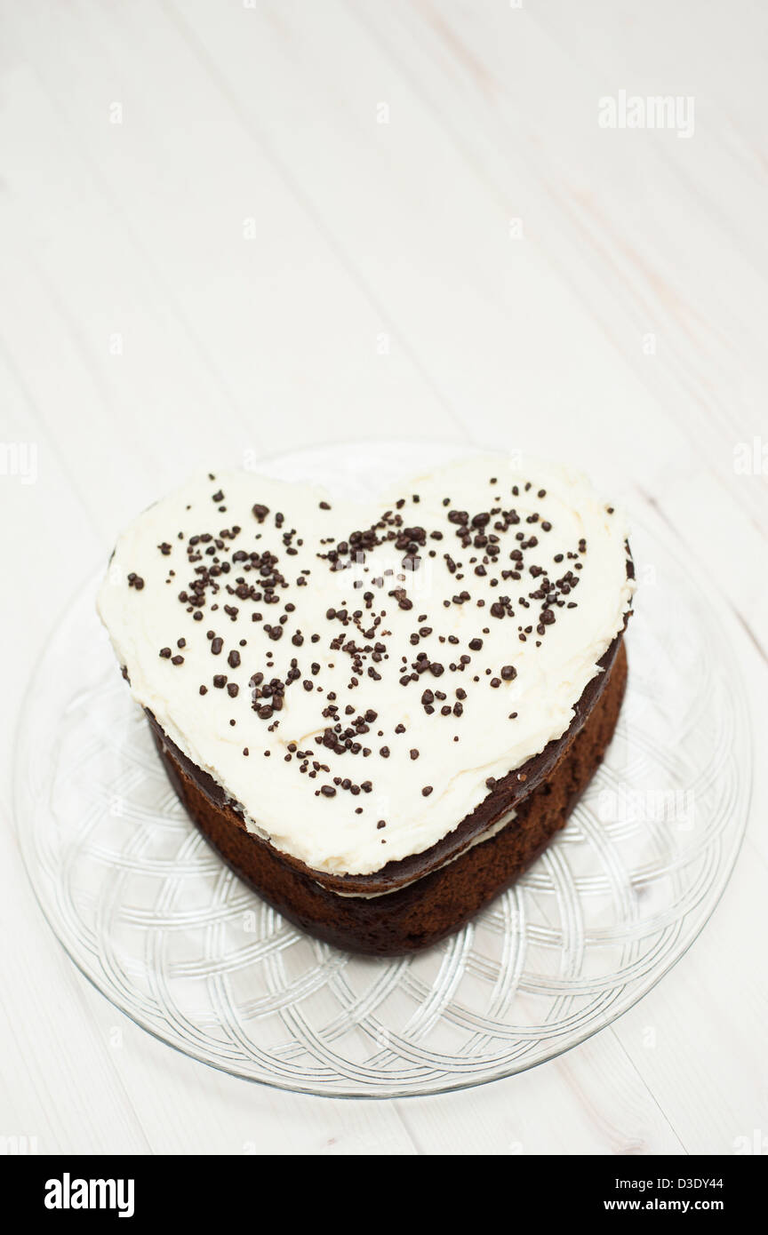 Gâteau au chocolat en forme de cœur avec crème au beurre vanille topping glaçage Banque D'Images