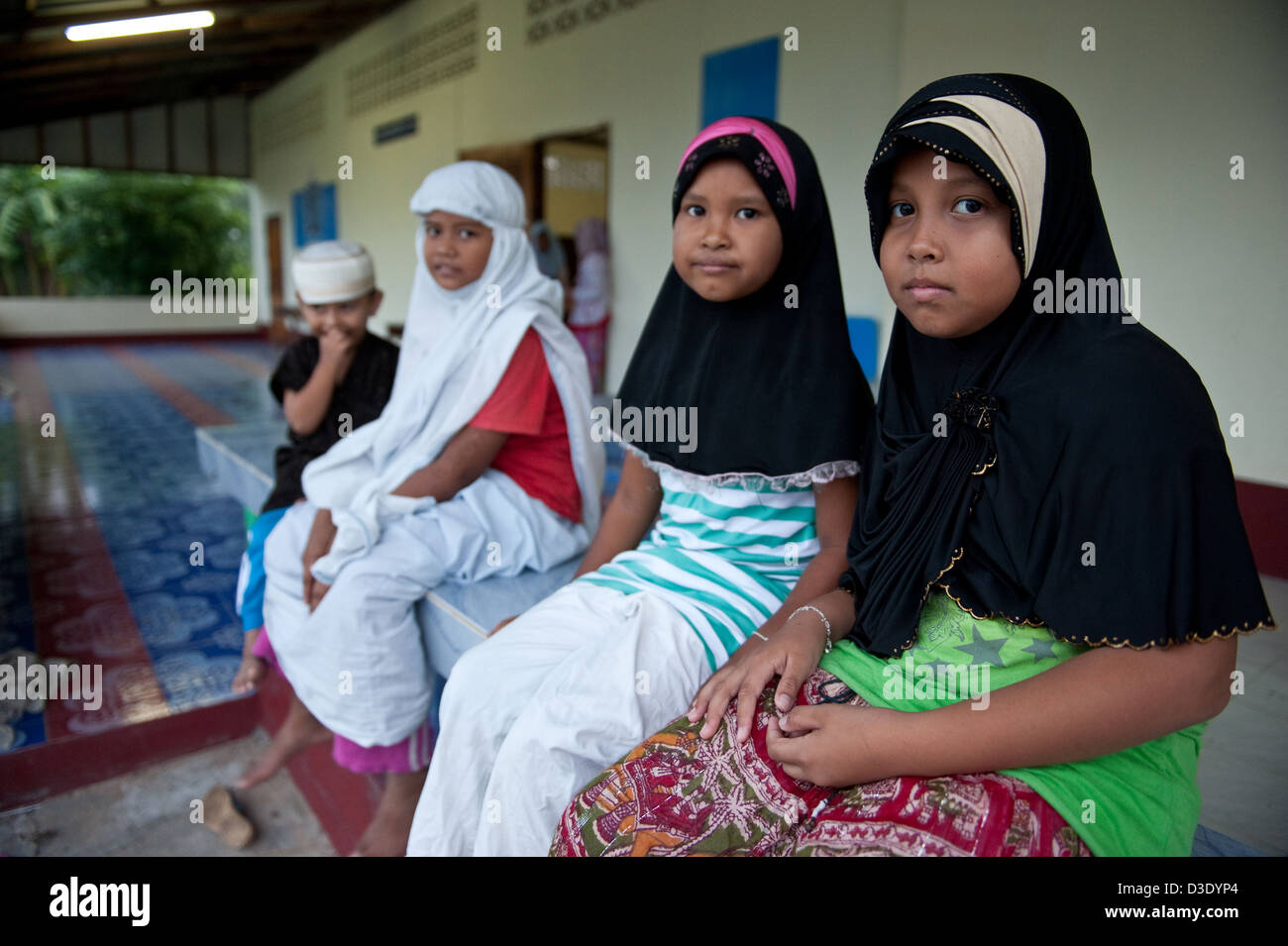 Koh Klong Prasong, Thaïlande, jeune musulmane assis en face de la mosquée du village Banque D'Images