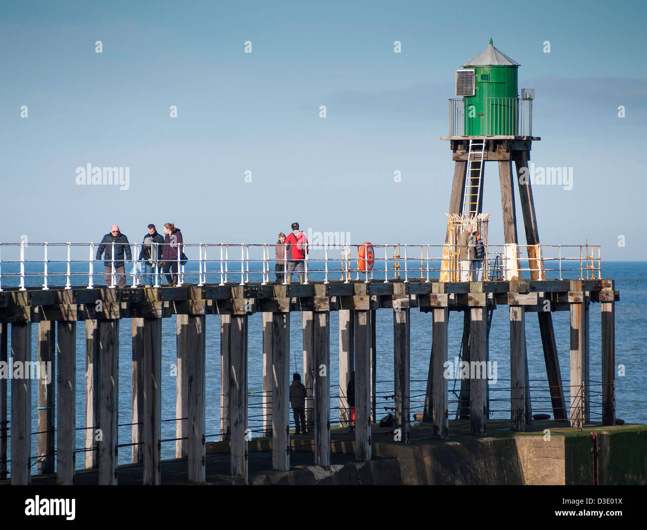 Les gens de marcher sur la jetée ouest Whitby sur une extension des hivers jour ensoleillé Banque D'Images