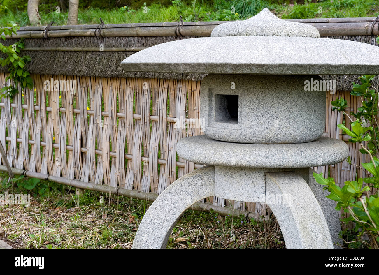 Jardin paysage japonais détail avec maru-yukimi lanterne de pierre et tissus de style bambou lattes de clôture entre verdure. Banque D'Images