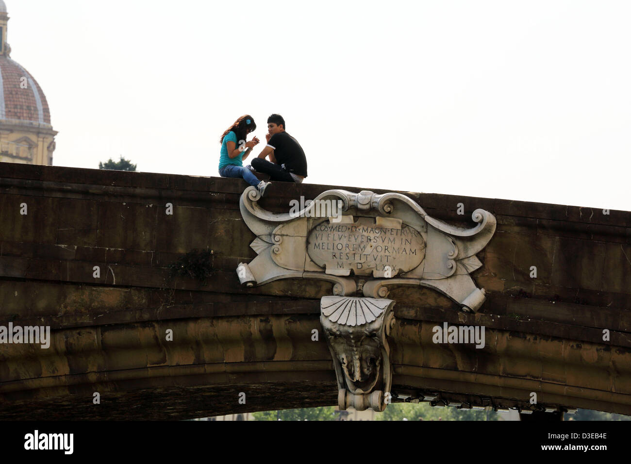 Young couple sitting on Ponte alle Grazie à Florence Italie Banque D'Images