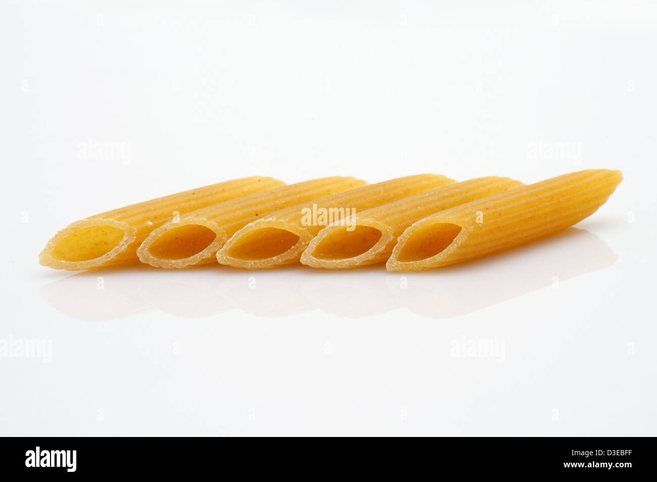 C'est un long tube creux, pâtes rigatoni en forme sur fond blanc. Banque D'Images
