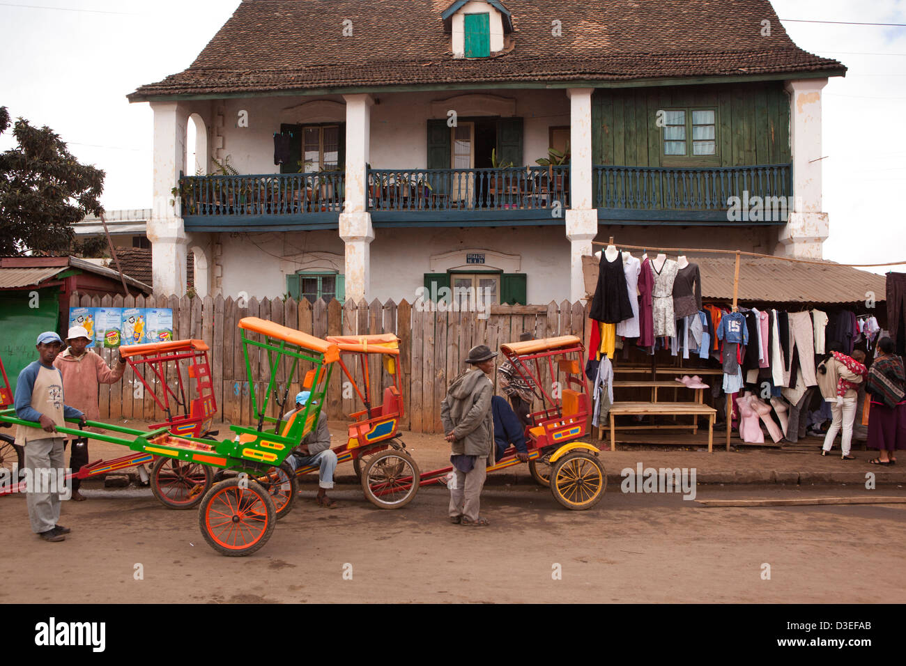 Antsirabe, Madagascar, pousse-pousse-pousse à l'extérieur de l'powered vieille maison coloniale Banque D'Images