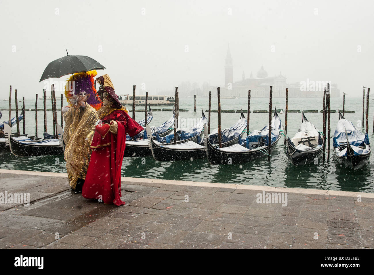 Les participants à poser pour les photographes de carnaval à Venise, au bord de l'eau lors de fortes chutes de neige. Banque D'Images