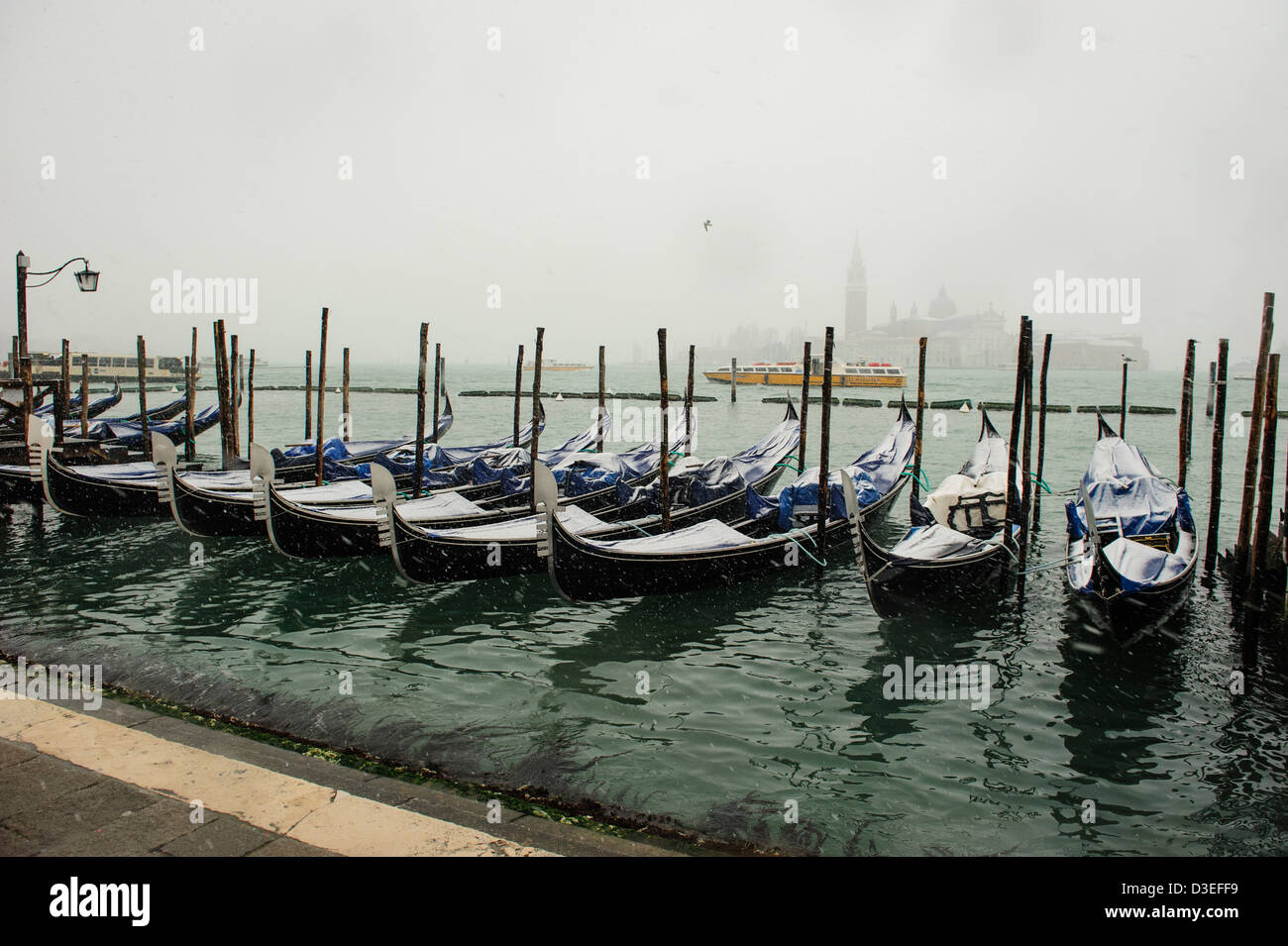 Gondoles couvertes de neige vu à Venise, au bord de l'eau au cours de la forte chute de neige et des conditions météorologiques à Venise. Banque D'Images