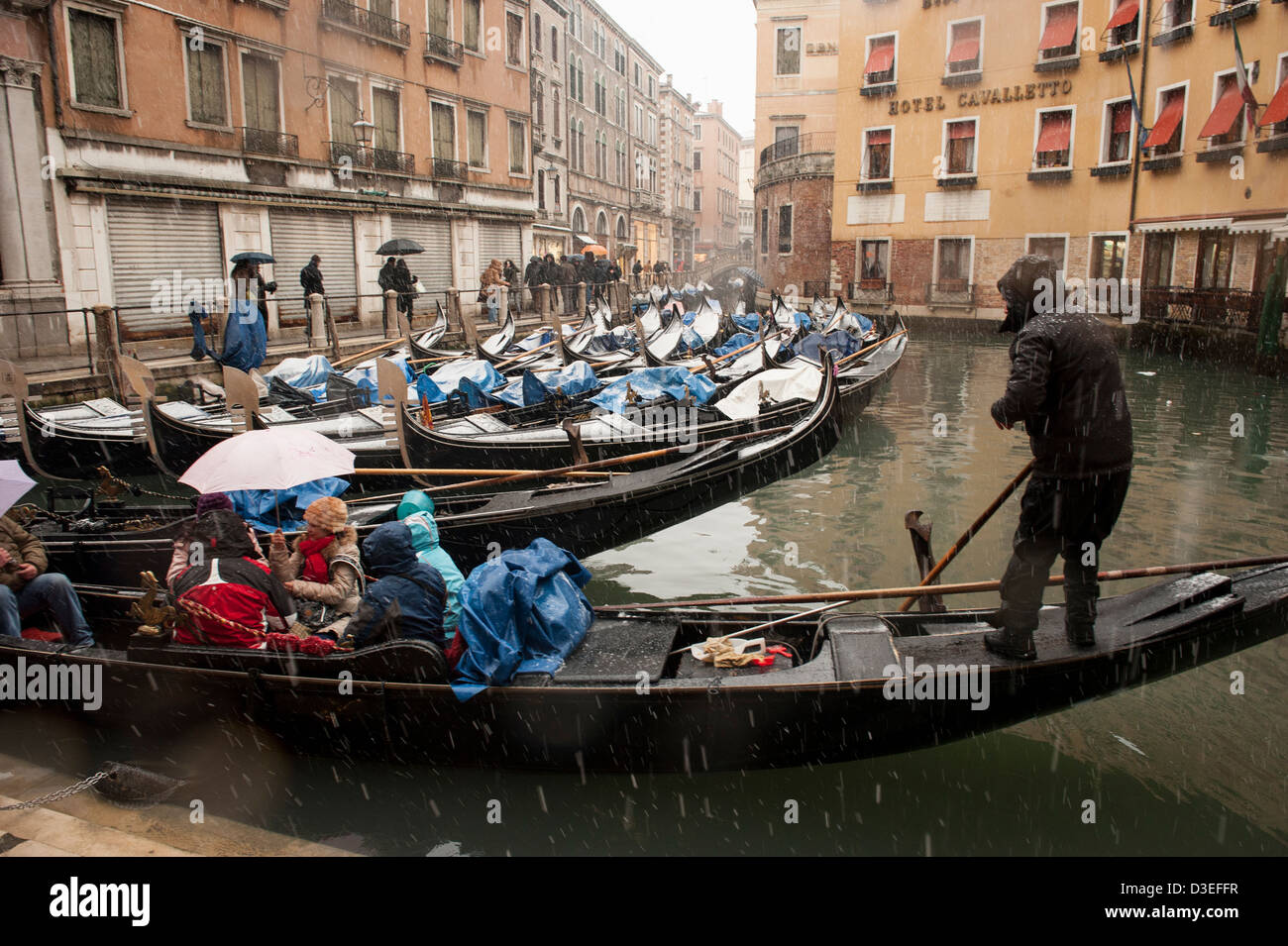 Un gondolier emmène les touristes pour une promenade en gondole au cours d'une forte chute de neige à Venise, Italie. Banque D'Images