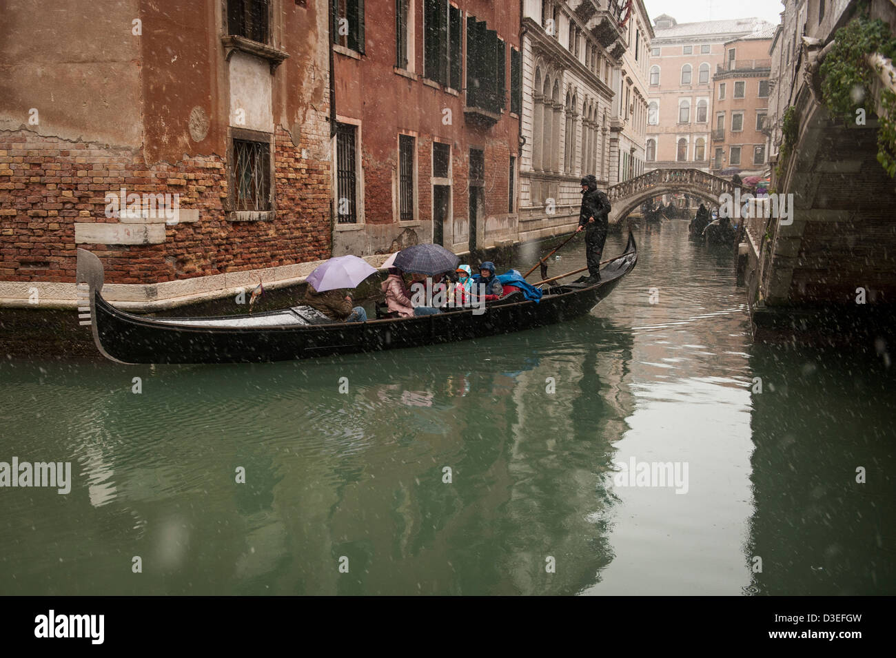 Un gondolier emmène les touristes pour une promenade en gondole au cours d'une forte chute de neige à Venise, Italie. Banque D'Images