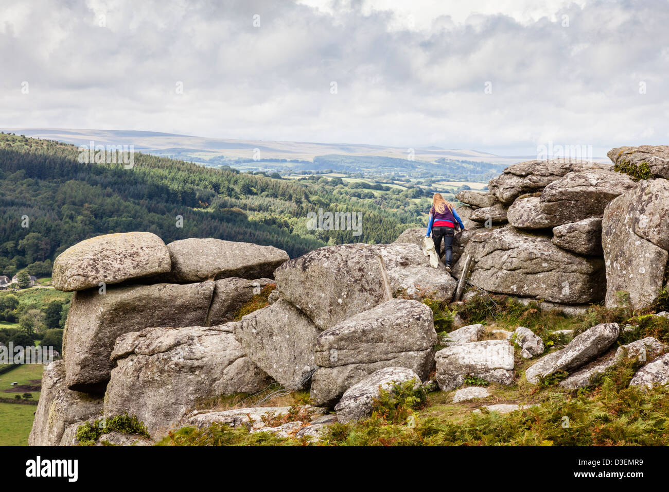 Les femmes monte affleurement rocheux sur Lustleigh Cleave, Devon, UK Banque D'Images