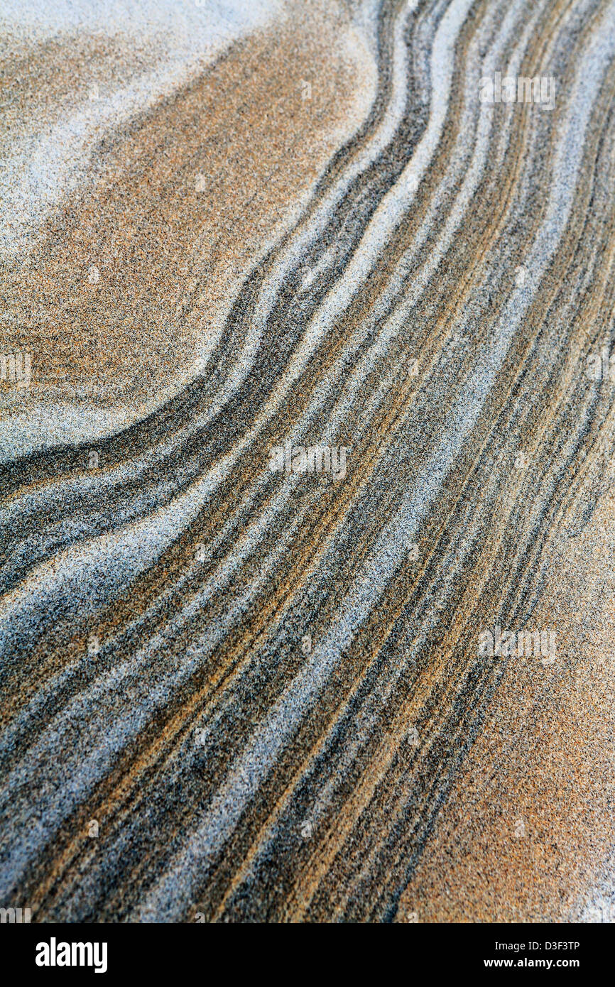 La texture du sable des dunes de sable avec différentes couleurs de particules de sable en couches dans le vent. Banque D'Images