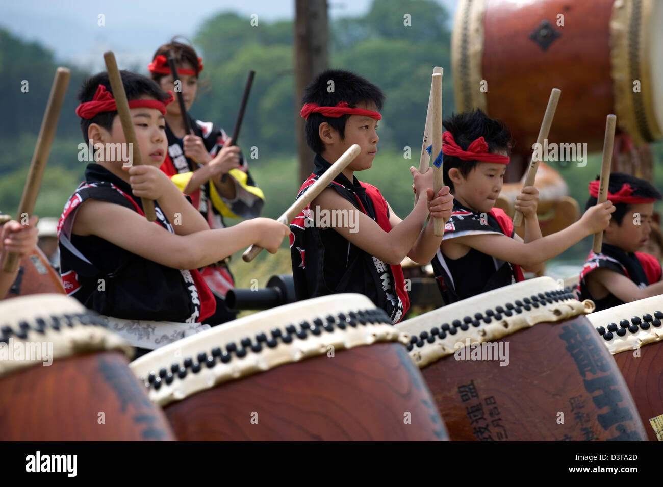 Groupe de jeunes percussionnistes garçon en tenue de fête, garder le rythme des tambours japonais, tout en offrant du divertissement à festival au Japon. Banque D'Images