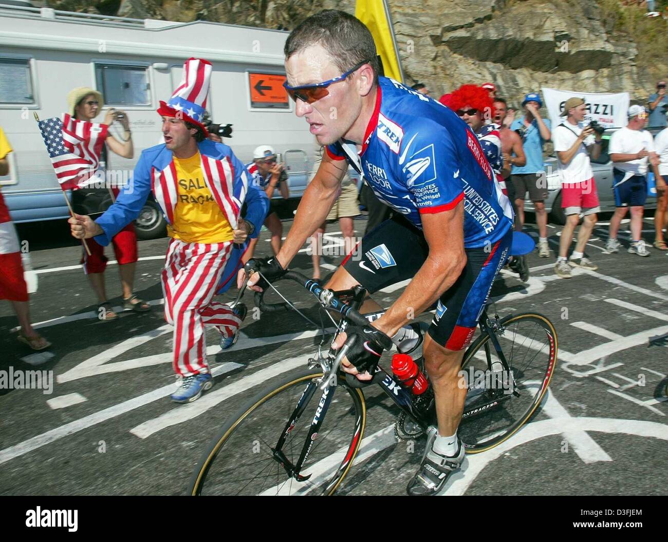 (Dpa) - US Postal-Berry Floor's Lance Armstrong de l'US obtient le soutien d'un ventilateur car il sprints pour la ligne d'arrivée à la fin de la 8e étape du Tour de France 2003 vélo course à l'Alpe d'Huez, France, 13 juillet 2003. Iban Mayo de l'Euskaltel-Euskadi depuis l'Espagne a remporté la 8e étape, Armstrong est arrivé en troisième place et a pris le maillot jaune de leader du général. La 8ème jambe est une montagne Banque D'Images