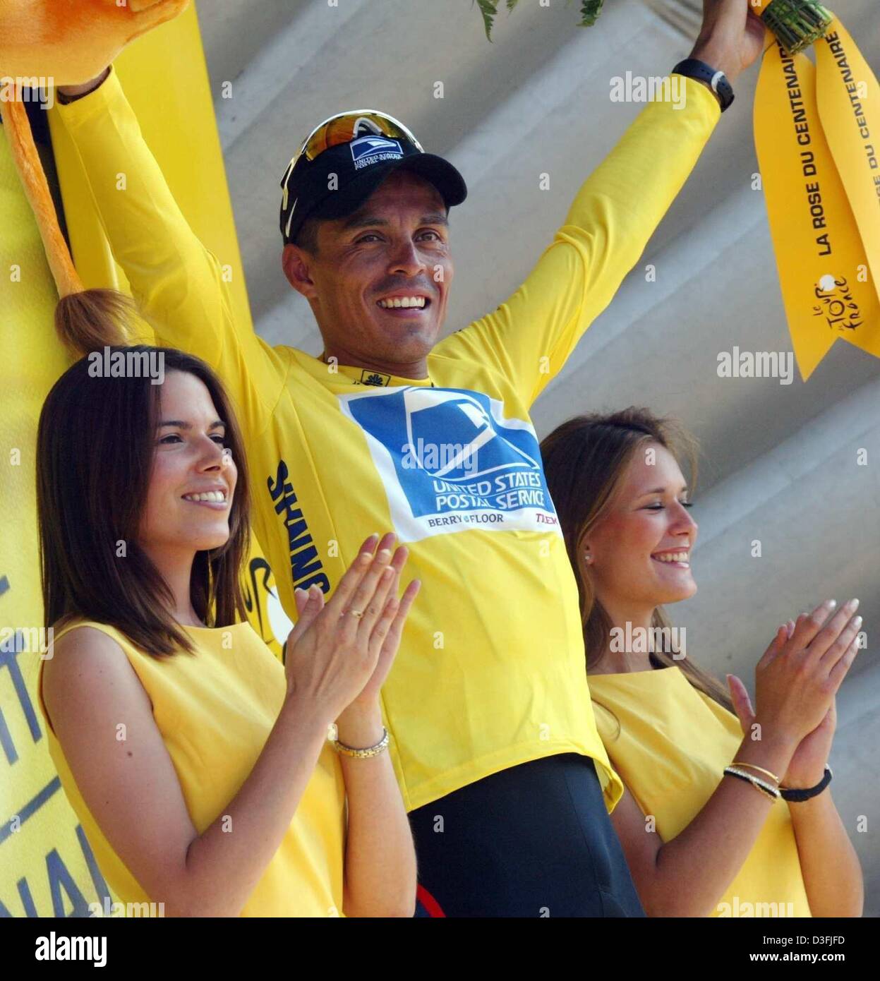 Victor Hugo Pena colombien d'ENTRE NOUS Postal-Berry Floor est flanquée de deux beautés sur le podium après avoir fixé le maillot jaune de leader à la suite de la cinquième étape du Tour de France 2003 cycliste de Troyes à Nevers, France, 10 juillet 2003. Pena fête ses 29 ans. La cinquième patte couvre une distance de 196,5 kilomètres. Banque D'Images