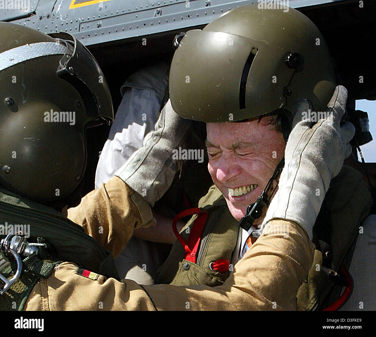 (Afp) - Un soldat assiste le président allemand Horst Koehler (R) d'ôter son casque comme il descend de l'hélicoptère à bord de la frégate Mecklenburg-Vorpommern au large de Djibouti, le 16 décembre 2004. Le chef de l'Etat allemand, qui est sur un 11-day tour de l'Afrique, a visité la frégate allemande qui est situé dans la Corne de l'Afrique où la marine allemande prend part à la lutte anti-terr Banque D'Images