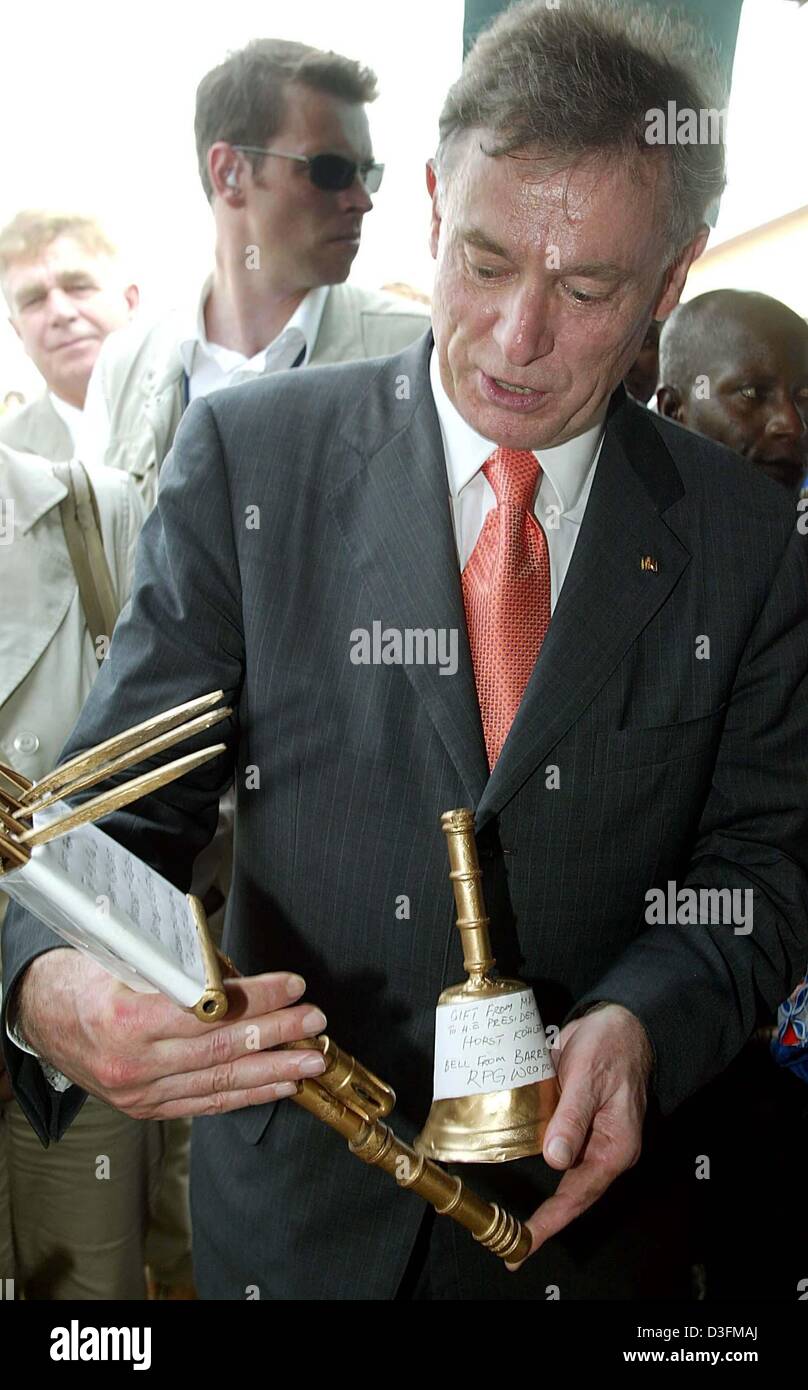 (Afp) - Le président allemand Horst Koehler examine les outils qui sont faits d'armes sur les rebuts youth training centre de la Gesellschaft für Technische Zusammenarbeit (Coopération technique allemande) de l'Agence à Waterloo, en Sierra Leone, le 8 décembre 2004. Koehler est sur une visite de quatre jours en Sierra Leone et se rendra au Bénin le Jeudi, 9 décembre 2004. Banque D'Images