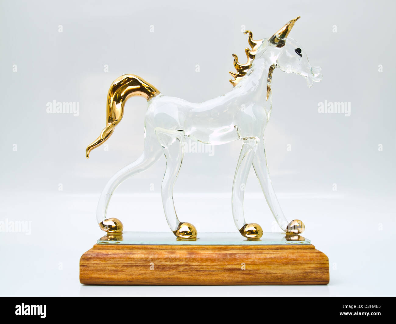 Un cheval en verre artisanat debout sur socle en bois dans le profil Voir isolé sur fond blanc Banque D'Images Un cheval en verre artisanat debout sur socle en bois dans le profil Voir isolé sur fond blanc Banque D'Images