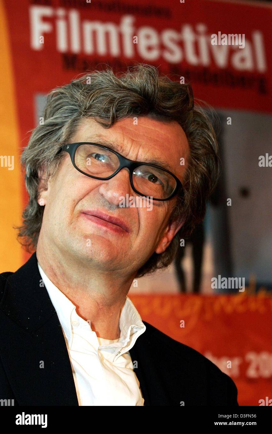 (Afp) - célèbre réalisateur allemand Wim Wenders se trouve en face d'une affiche à Mannheim, Allemagne, 24 novembre 2004. Wenders, qui vit aux Etats-Unis, a reçu le "maître d'Cinema-Award' pour son œuvre en marge de la 53e International Filmfestival Mannheim-Heidelberg. Banque D'Images