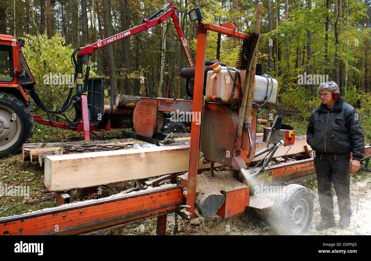 (Afp) - Dieter Lehmann de l'entreprise "d'être Holz- und Verarbeitung' (le traitement du bois et de la transformation) fonctionne sur une scierie mobile dans une forêt privée près de Briesen, Allemagne, le 8 novembre 2004. En particulier les propriétaires de forêts privées utiliser la possibilité de découper les planches et les planches à la tache avec une scierie mobile. Banque D'Images