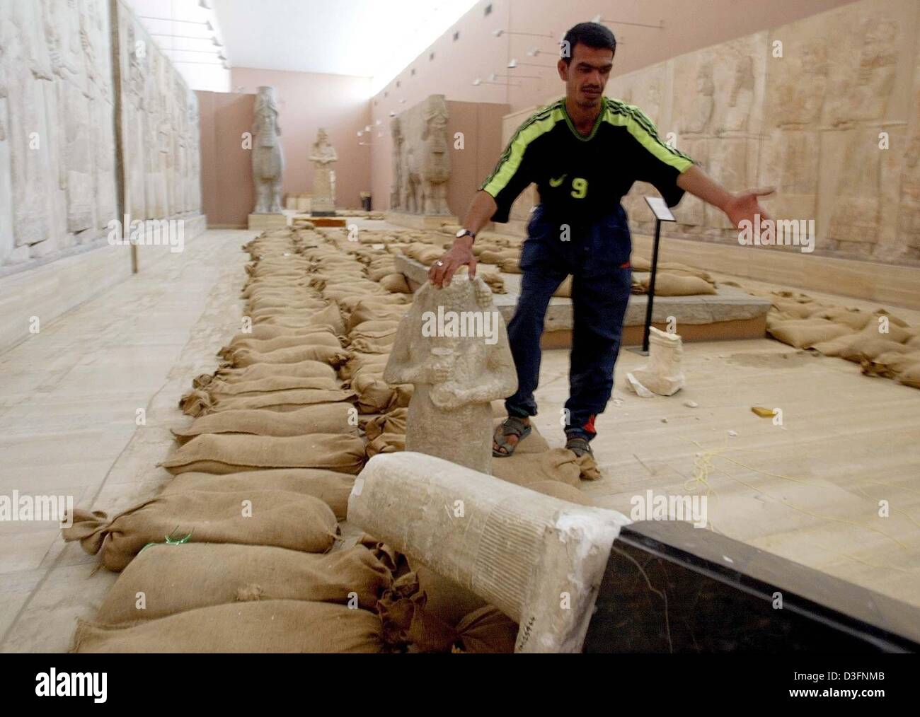 (Afp) - Un homme irakien affiche une statue antique cassé dans le Musée National irakien à Bagdad, Iraq's capital, 12 avril 2003. Le Musée National irakien a été partiellement pillé par les citoyens au cours des deux derniers jours. Les Irakiens ont exprimé leur frustration face à l'anarchie croissante dans la capitale, qui s'est poursuivi pour une quatrième journée consécutive samedi depuis l'arrivée de soldats américains et d'e Banque D'Images