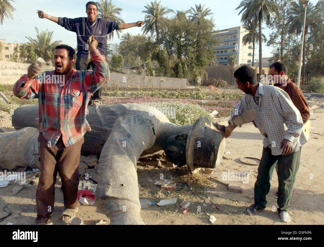 (Afp) - Les Irakiens célèbrent autour d'un renversé statue de leader irakien Saddam Hussein, le 12 avril 2003. Les forces américaines ont lancé un appel à la police irakienne pour aider à rétablir l'ordre dans la capitale irakienne. Banque D'Images