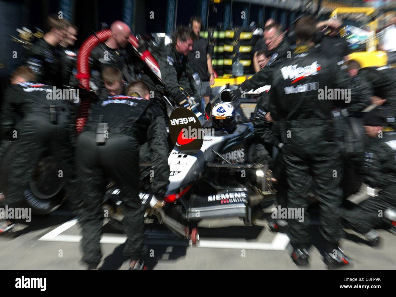 (Afp) - mécanique de l'équipe McLaren Mercedes répéter un pit stop sur la piste de course à Melbourne, Australie, 5 mars 2003. La saison de Formule 1 2003 s'ouvre ce week-end à Melbourne. Banque D'Images