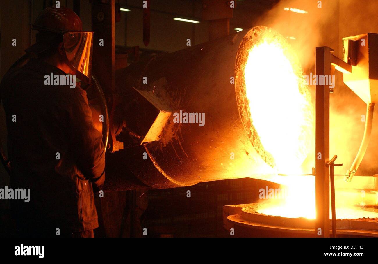 (Afp) - un travailleur comme moniteurs de fer fondu est décanté dans l'Duktil Guss casting company à Fuerstenwalde, Allemagne, 22 janvier 2003. L'entreprise produit principalement des matchs pour le gaz et l'eau, ainsi que des pièces de moteur pour les camions. Banque D'Images