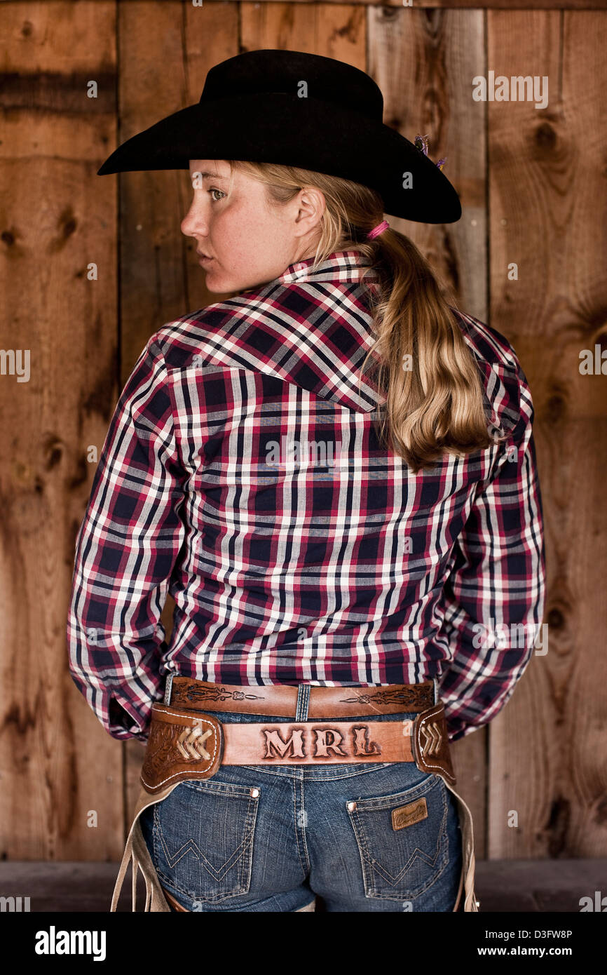 Wrangler Cowgirl debout avec chemise à carreaux, vue arrière, Montana, USA Banque D'Images