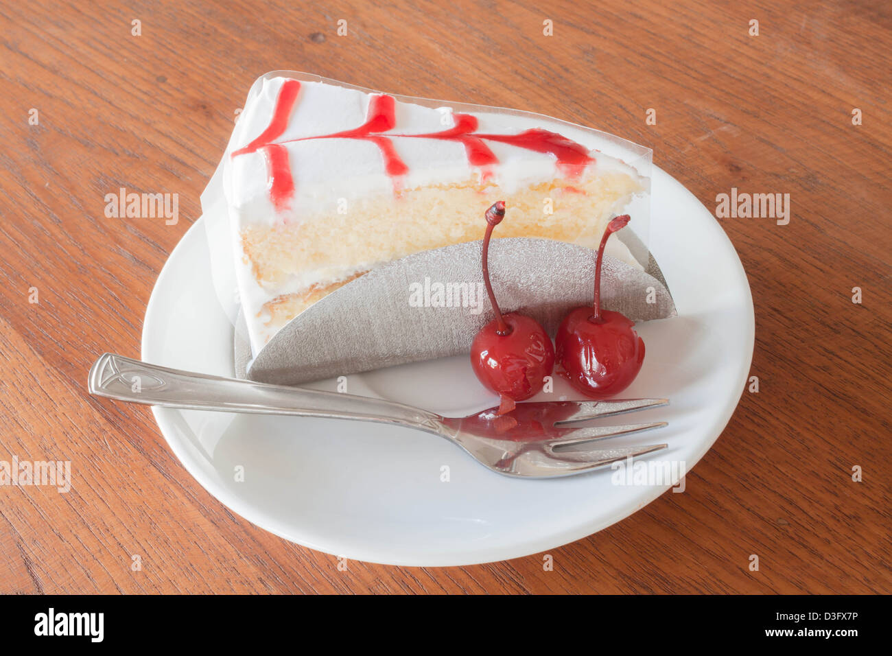 Gâteau à la vanille avec cerise sur fond de bois Banque D'Images