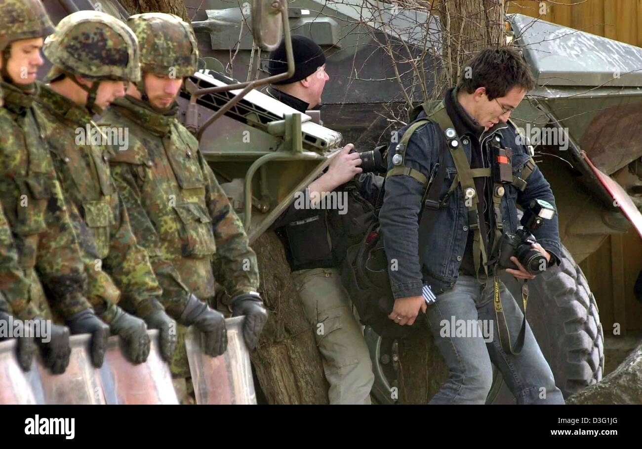 (Afp) - Deux photographes prendre dès qu'ils se cachent de tireurs d'élite à la zone d'entraînement militaire à Hammelburg, Allemagne, 20 mars 2003. Ils sont les participants à la formation de base pour la protection et la conduite dans les régions de guerre pour les journalistes. En cinq jours les journalistes qui auront à travailler dans les zones d'instabilité sont préparés pour l'speacial dangers les attendent dans ces régions Banque D'Images
