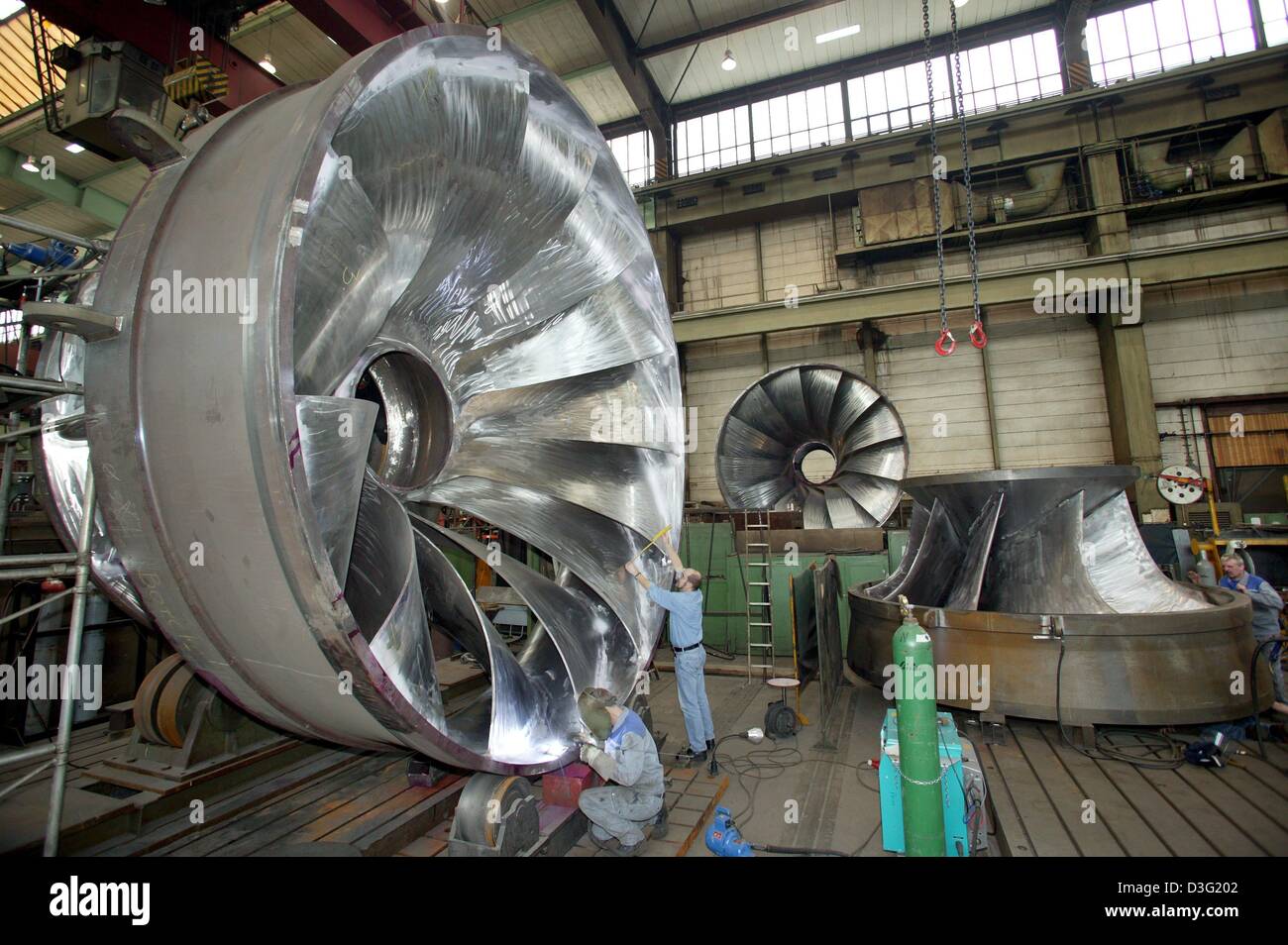 (Afp) - Les travailleurs de l'usine machine Voith construire une roue de turbine d'un diamètre de cinq mètres, Heidenheim, Allemagne, 7 mars 2003. L'éolienne sera installée dans la station d'énergie hydroélectrique Borcha en Turquie. Banque D'Images