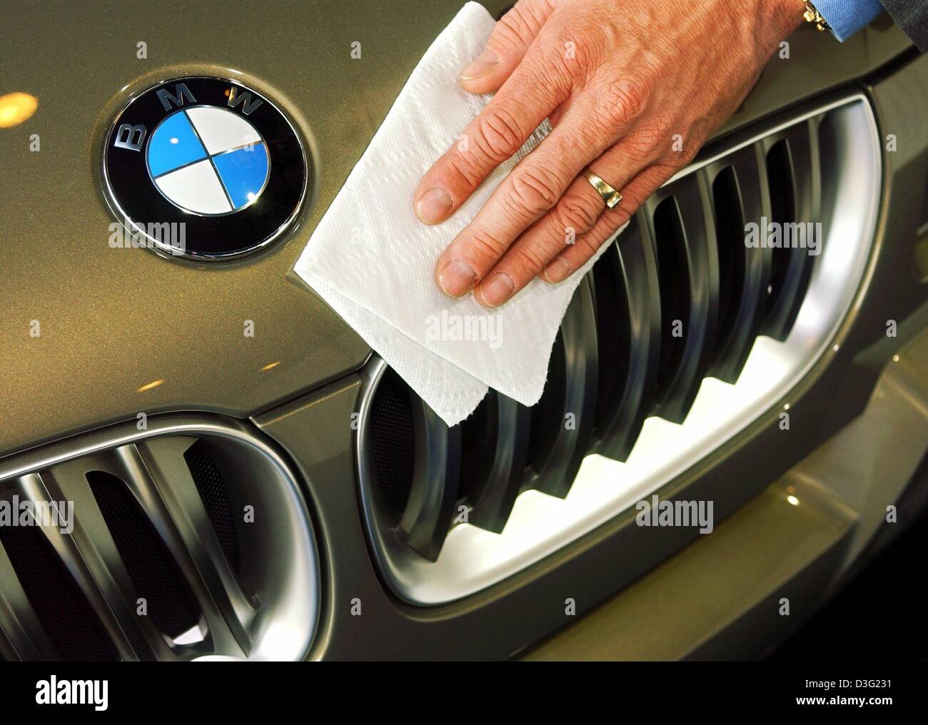 (Afp) - un essuie-mains le capot et le logo BMW soigneusement avec un morceau de tissu dans Munich, Allemagne, 19 mars 2003. BMW, le constructeur de voitures allemand affirme que l'entreprise s'attendait à sortir seulement télévision cette année grâce à la hausse des dépenses liées aux nouveaux modèles. Les initiatives de marketing et de produits notables cette année conduirait à un niveau exceptionnellement élevé de dépenses en 2003. Banque D'Images