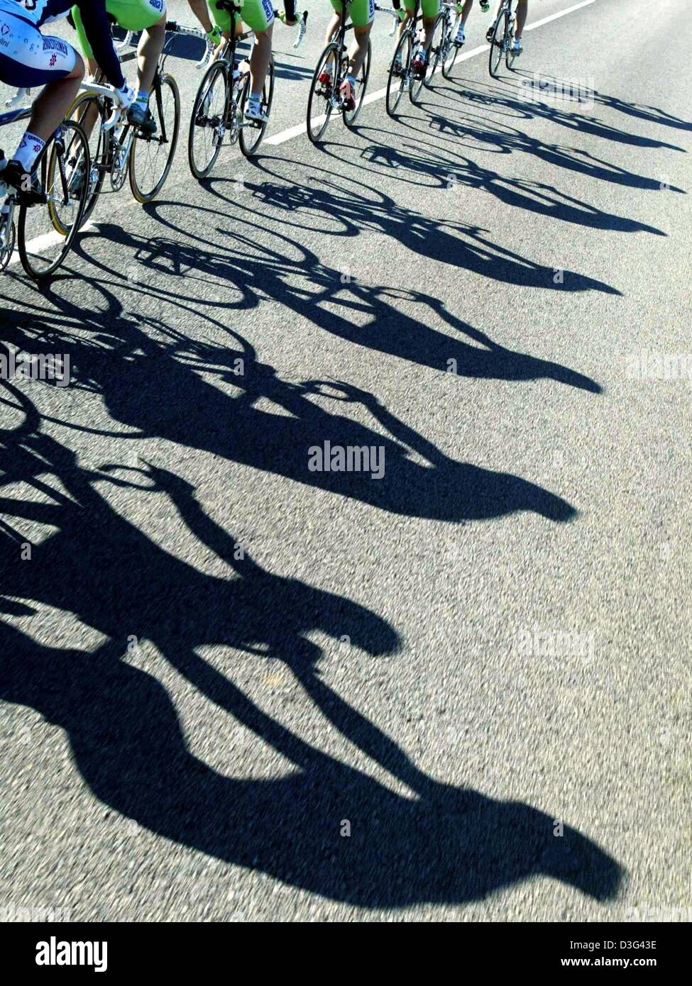(Afp) - Les grandes ombres de cyclistes sont exprimés sur l'asphalte d'une route en Cala Ratjada, Espagne, le 3 février 2003. Banque D'Images