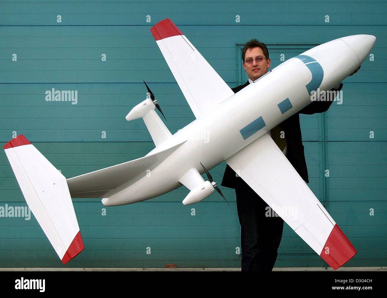 (Afp) - Christian Majunke, concepteur en chef de la société d'avions à haute performance, présente le modèle d'un nouveau commercial airplane au siège de la société à Kritzow, Allemagne, 28 janvier 2003. L'avion quatre sièges passagers et un pilote. Les deux rotors sont fixées à l'arrière de l'avion et sont alimentés par un moteur diesel V8, ce qui réduit la consommation d'essence par ha Banque D'Images