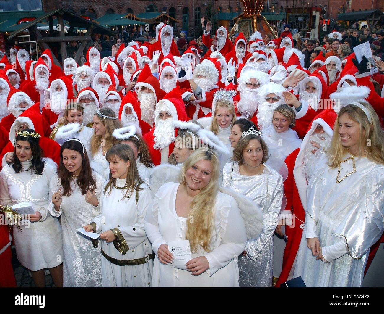 (Afp) - Les étudiants habillés comme des anges et Santa Clauses ont se sont réunis à Berlin, le 30 novembre 2003. Le Père Noël et anges seront disponibles à la veille de Noël pour faire des visites à domicile et de distribuer des cadeaux de Noël qu'à une famille d'arbres de Noël. Banque D'Images