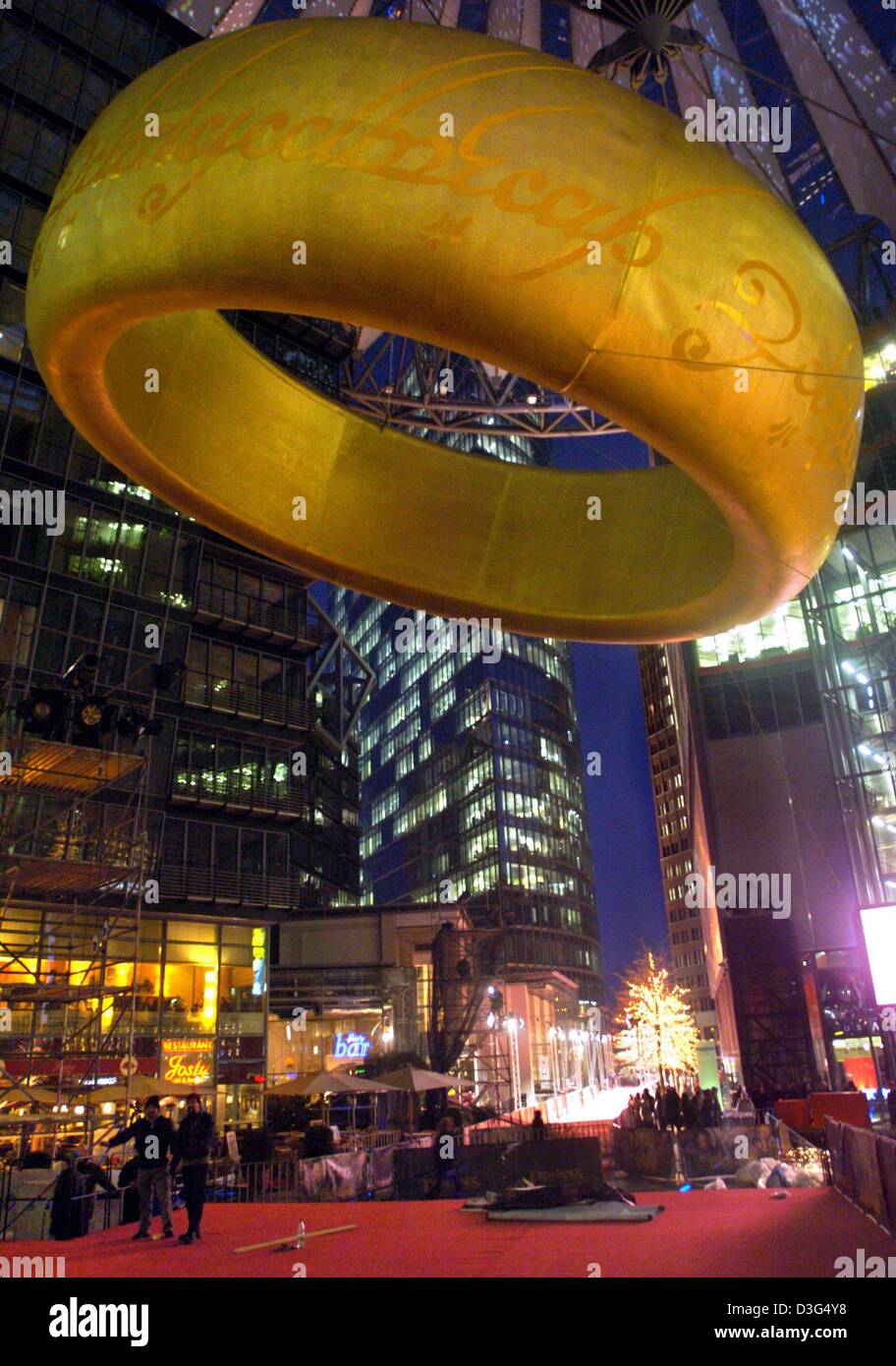 (Afp) - Un anneau d'or géant dangles sur le tapis rouge en face du Sony Center de Berlin, 9 décembre 2003. La première européenne du film 'Le Seigneur des Anneaux - Le Retour du Roi" a eu lieu ici le 10 décembre. Banque D'Images