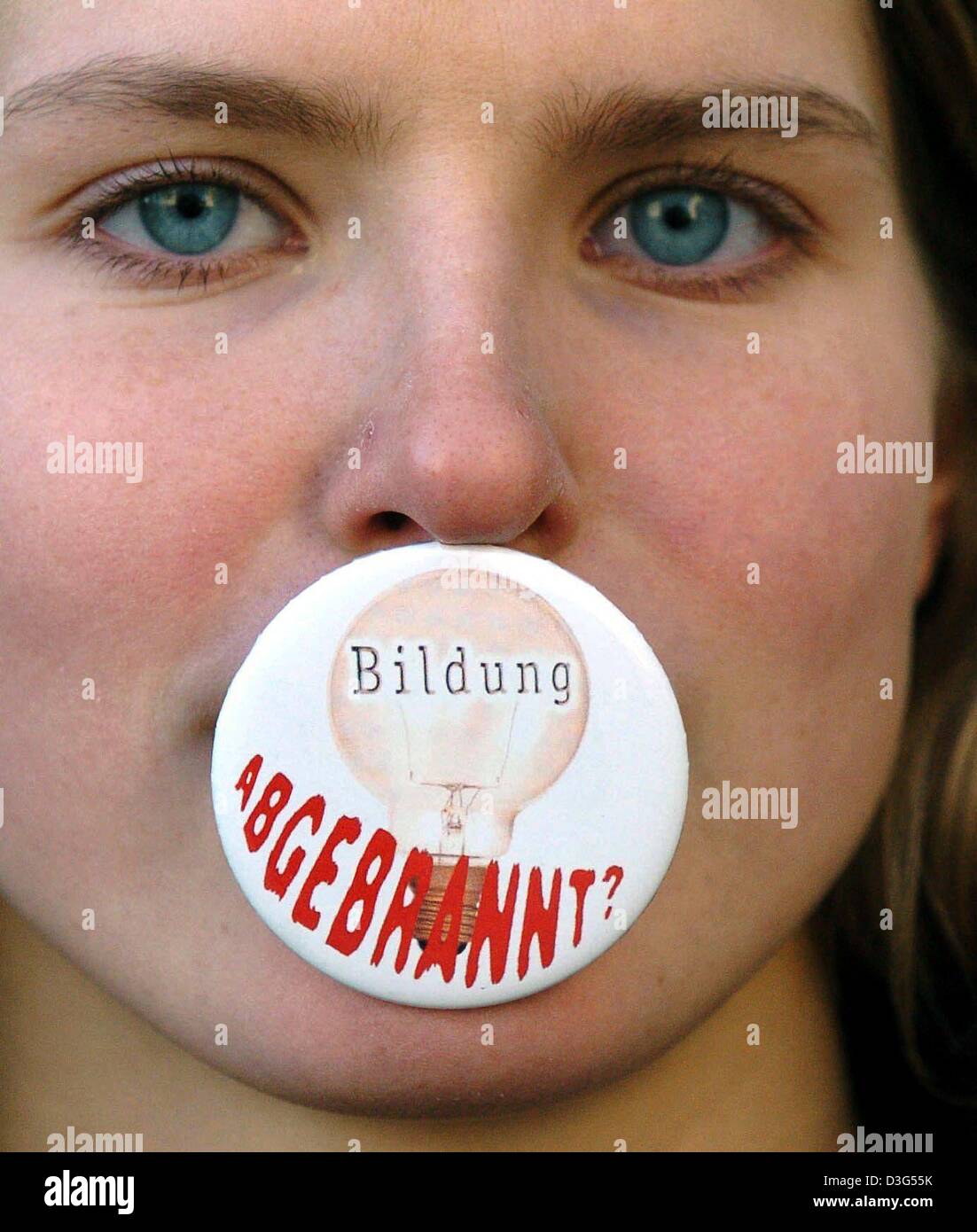 (Afp) - un étudiant Christiane Hupe a bouton grève en bouche pour protester contre le projet de réduire le financement des universités, à l'université Martin-Luther de Halle-Wittenberg Halle, Allemagne de l'Est, 8 décembre 2003. Le bouton affiche une ampoule et lit « Bildung abgebrannt ?' (qui a le double sens de "l'éducation en cendres" et "l'éducation s'). Une semaine du début des manifestations Banque D'Images