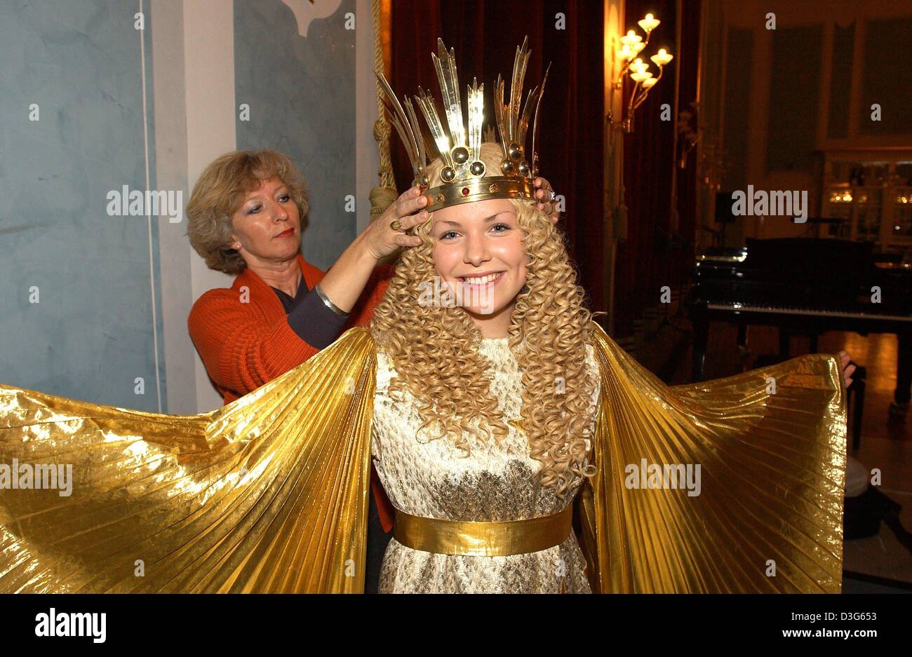 (Afp) - Helke Hardlich, chef maquilleuse de l'opéra, applique les dernières touches au costume de 17 ans Christin Strauber, qui est habillé comme un enfant du Christ, au cours de la répétition générale de Nuremberg, Allemagne, 17 novembre 2003. La répétition générale et la présentation à la presse de l'enfant Christ a lieu traditionnellement à l'avance de l'ouverture de la célèbre N Banque D'Images