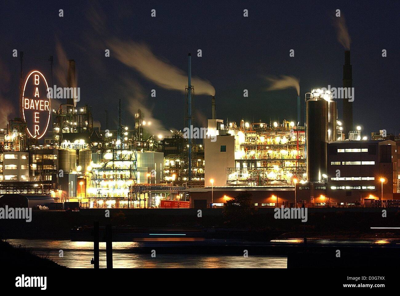 (Afp) - Une vue de l'allumé la croix Bayer et l'enceinte de l'usine de produits chimiques Bayer Leverkusen, Allemagne, 21 octobre 2003. Banque D'Images