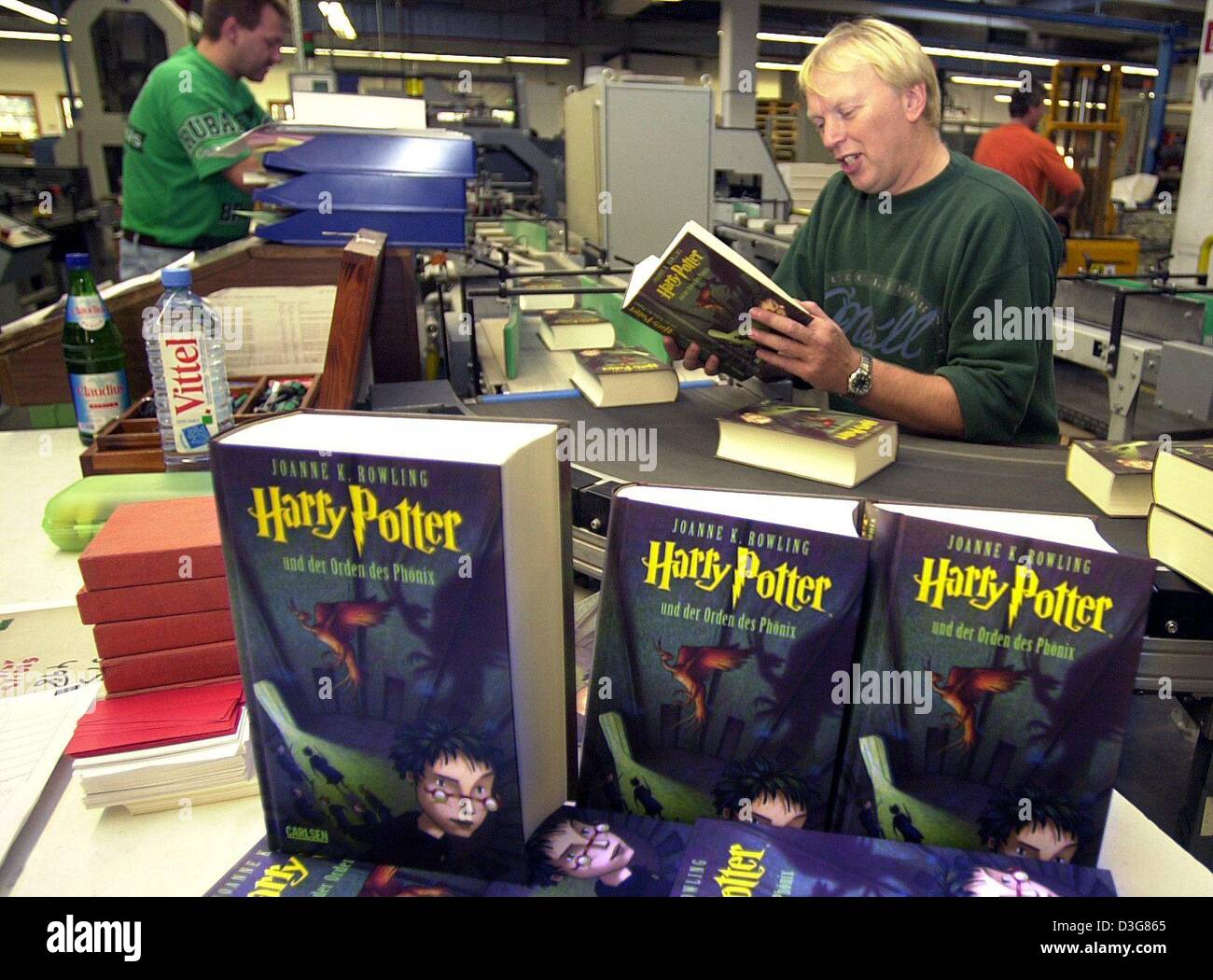 (Afp) - Bernd Johannsen (R) exmines la nouvelle copie du dernier volume de Harry Potter à la 'Clausen et Bosse' imprimerie Leck, Allemagne, 27 octobre 2003. La production de l'édition allemande fonctionne à pleine vitesse comme plus de 50 gros camions se beloaded avec le temps tous les livres préférés et livrés aux différents stands de vente des librairies et dans toute l'Allemagne Banque D'Images