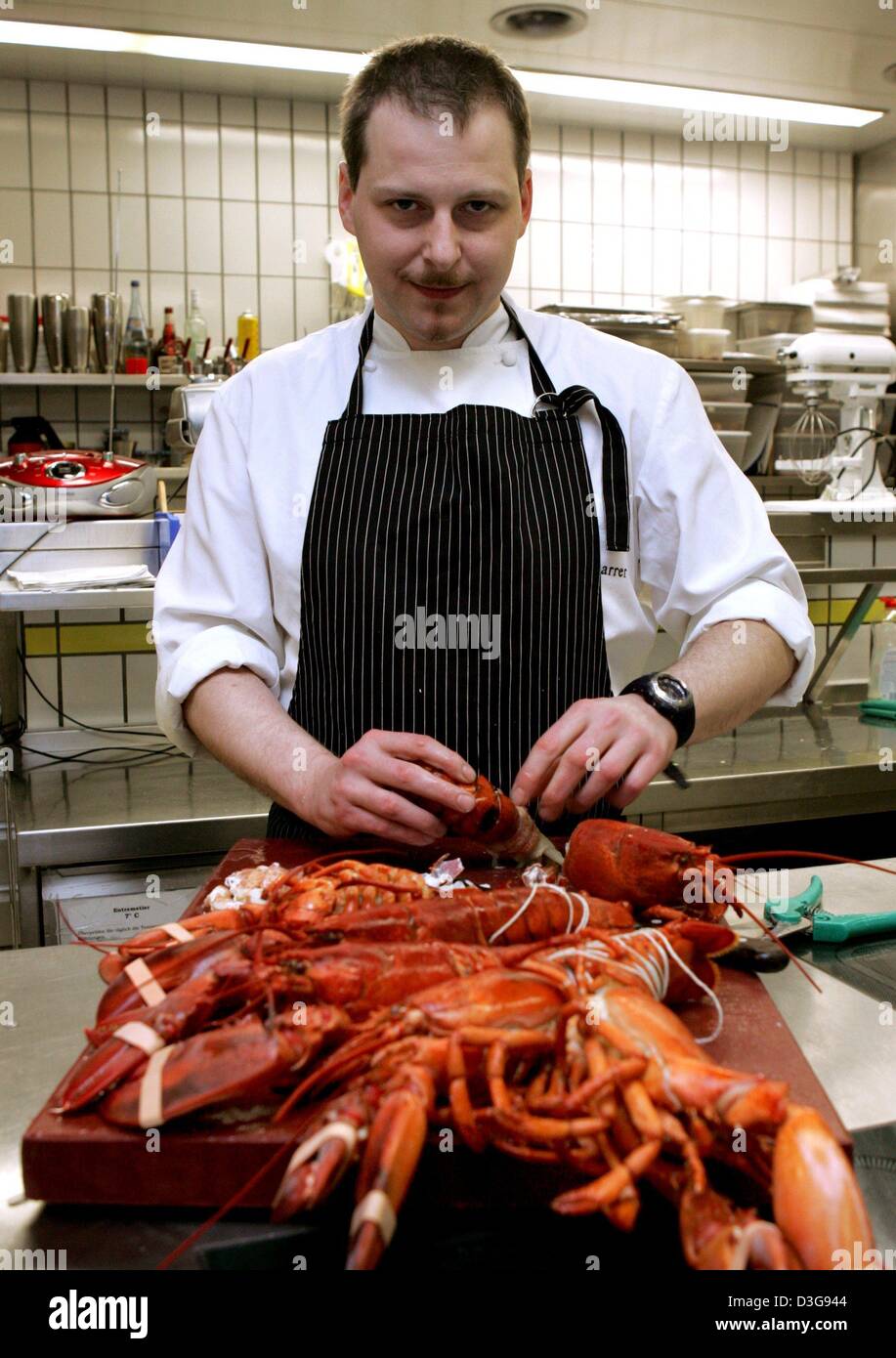 (Afp) - Christian Scharrer, chef du restaurant Imperial à l'hôtel château Buehlerhoehe, prépare le homard dans la cuisine de l'Imperial en Buehl, Allemagne, 16 novembre 2004. Scharrer le mercredi soir, 17 novembre 2004, a été couronné "cuisinier de l'année' par l'influent le guide Gault Millau. L'homme de 33 ans a reçu le prix de l'opulence et la diversité de la hi Banque D'Images