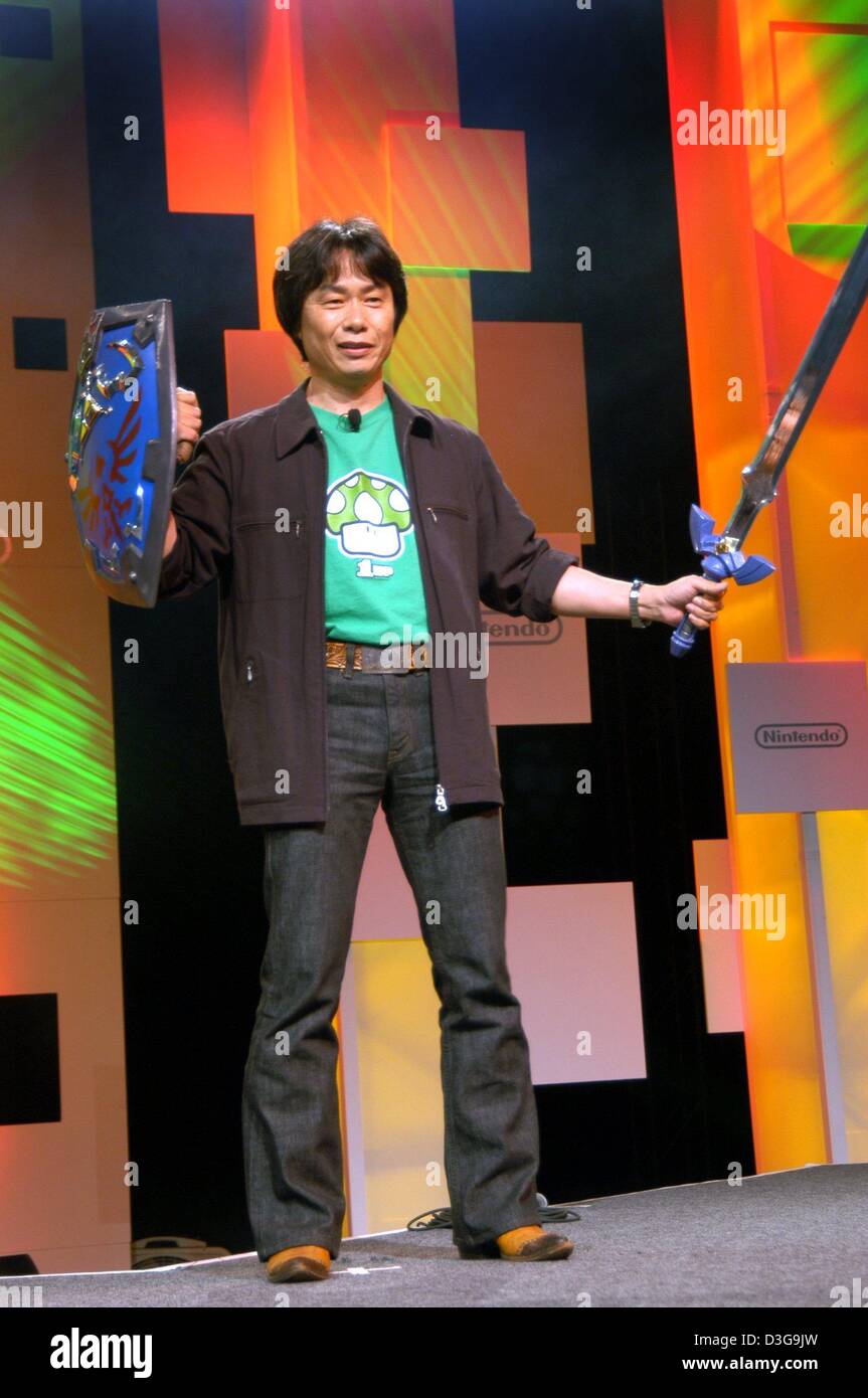 (Afp) - Shigeru Miyamoto, directeur général de Nintendo, est titulaire d'un shiled et une épée dans ses mains au cours d'une présentation de la nouvelle palette de jeu mobile Nintendo DS (double écran) à l'Electronic Entertainment Expo (E3), salon de jeux vidéo et informatiques, à Los Angeles, Californie, USA, 11 mai 2004. Miyamoto est aussi connu sous le nom de 'Steven Spielberg des jeux vidéo". Banque D'Images
