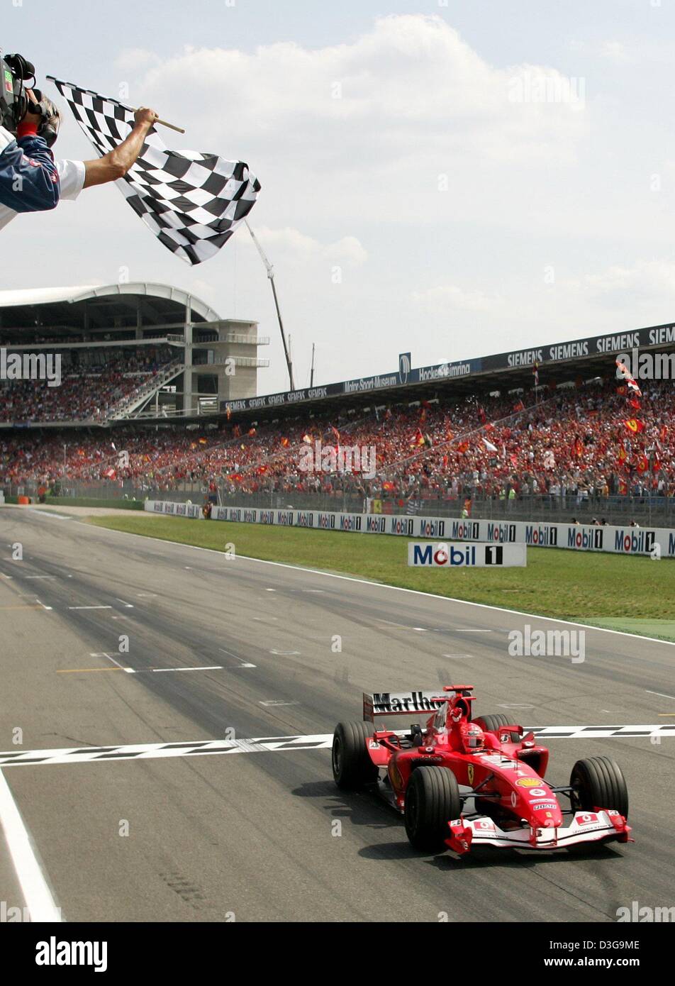 (Afp) - une autre race, un autre drapeau à damiers pour Schumacher et son équipe Ferrari. Pilote de Formule 1 l'Allemand Michael Schumacher remporte le Grand Prix d'Allemagne à Hockenheim, Allemagne, 25 juillet 2004. Le champ de formule 1 a remporté un nombre record de 11 de 12 courses cette saison de course. Banque D'Images