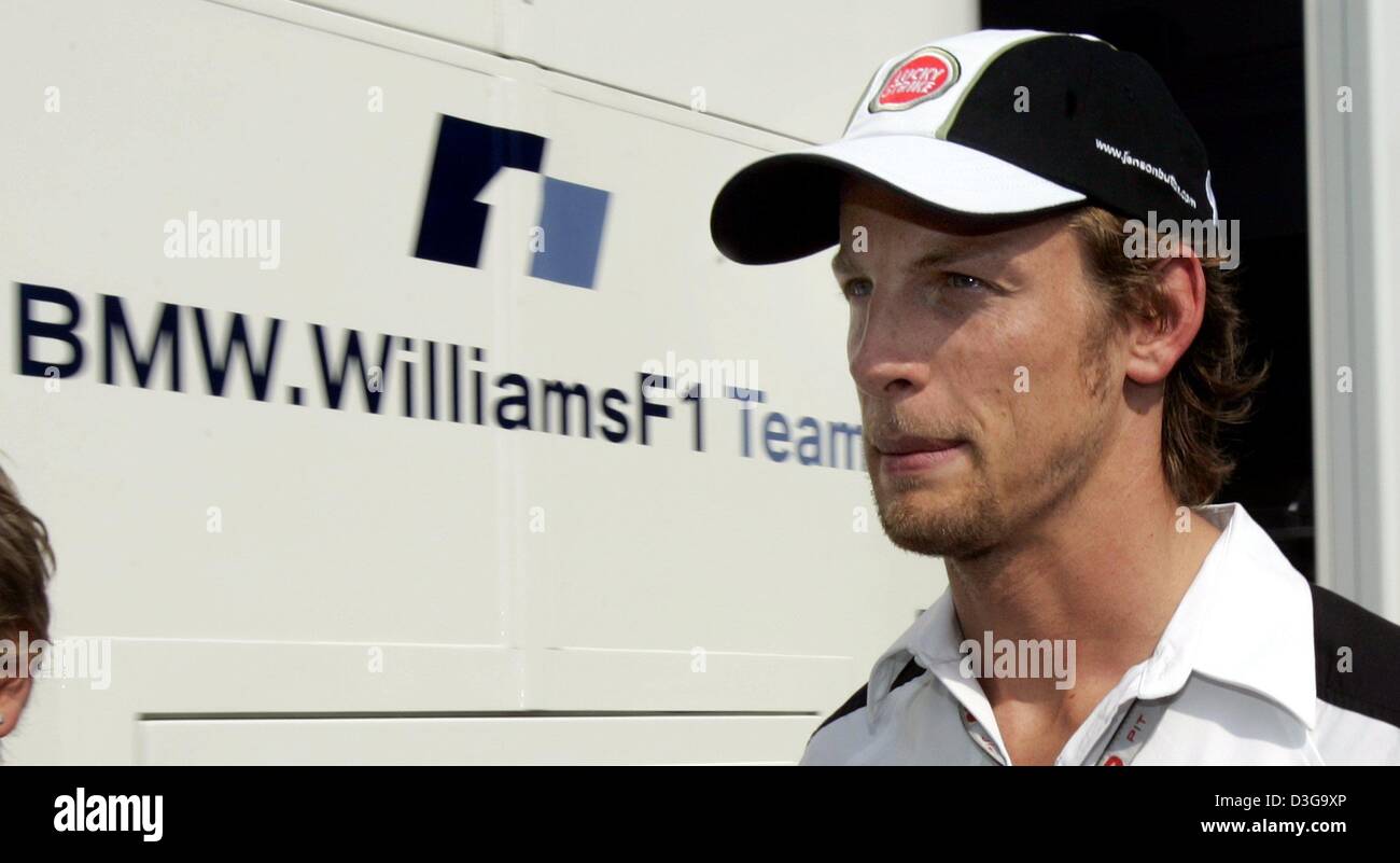 (Dpa) - pilote de Formule 1 britannique Jenson Button (BAR-Honda) de l'équipe passe devant le camping-car de l'équipe BMW-Williams dans le paddock de course sur le Hungaroring, près de Budapest, Hongrie, 12 août 2004. Bouton qui avait l'intention de changer les équipes et prévu de conduire pour BMW-Williams en 2005 demeurera à BAR-Honda pour une autre saison après la reconnaissance des contrats de Formule Un a décidé e Banque D'Images