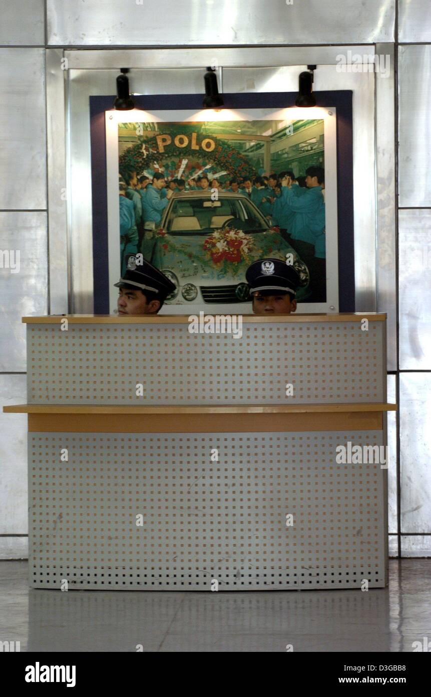 (Afp) - Deux hommes assis devant une photo montrant le début de la VW Polo-production dans l'usine du partenaire d'Joint-entreprise chinois 'Shanghai' de l'industrie automobile à Shanghai, Chine, 12 octobre 2004. L'entreprise coopérative 'Shanghai Volkswagen Automotive Company Ltd." (SVW), où les modèles VW Santana, Passat, Polo et Golf IV sont fabriqués, fête ses 20 ans un Banque D'Images