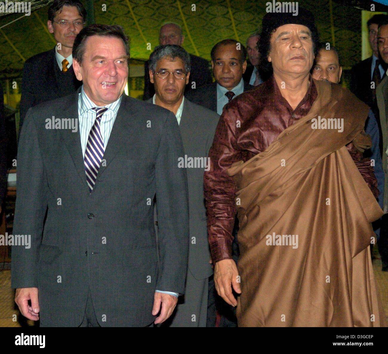 (Afp) - Le Chancelier allemand Gerhard Schroeder (L) est accueilli par le dirigeant libyen Mouammar Kadhafi (R) comme il arrive pour des conférences dans une tente traditionnelle à Tripoli, Libye, jeudi 14 octobre 2004. Schroeder est arrivé ici jeudi soir pour le lancement de son premier de deux jours visite en Libye, la première par un leader allemand de 25 ans. Au niveau politique, les autorités de Berlin a déclaré que la visite Banque D'Images