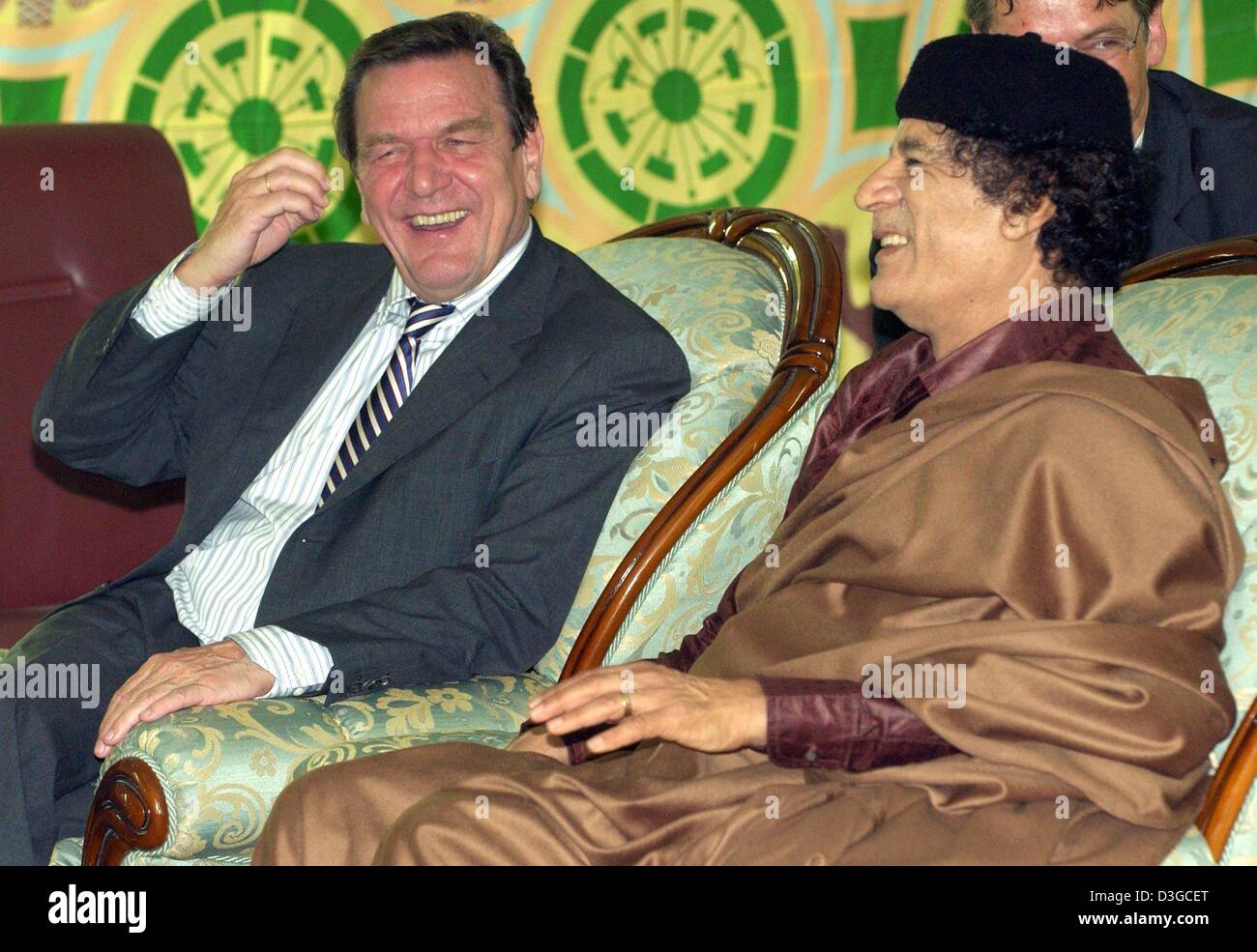 (Afp) - Le Chancelier allemand Gerhard Schroeder (L) s'entretient avec le leader libyen Mouammar Kadhafi (R) à une tente traditionnelle à Tripoli, Libye, jeudi 14 octobre 2004. Schroeder est arrivé ici jeudi soir pour le lancement de son premier de deux jours visite en Libye, la première par un leader allemand de 25 ans. Au niveau politique, les autorités de Berlin a déclaré que la visite vise à encourager l Banque D'Images