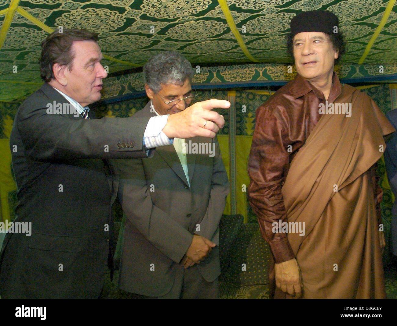 (Afp) - Le Chancelier allemand Gerhard Schroeder (L) rencontre le dirigeant libyen Mouammar Kadhafi (R) pour des entretiens à une tente traditionnelle à Tripoli, Libye, jeudi 14 octobre 2004. Schroeder est arrivé ici jeudi soir pour le lancement de son premier de deux jours visite en Libye, la première par un leader allemand de 25 ans. Au niveau politique, les autorités de Berlin a déclaré que la visite vise à encourager Li Banque D'Images